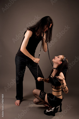 sendual young gothic couple playing role game isolated on gray