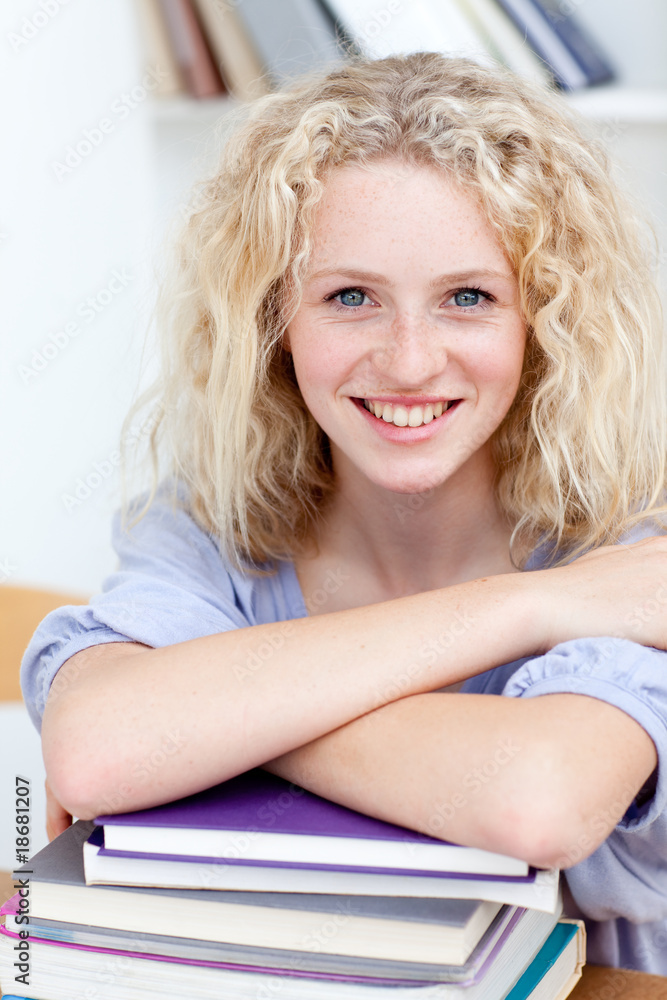Smiling teeenager studying lots of books Smiling teeenager studying lots of books