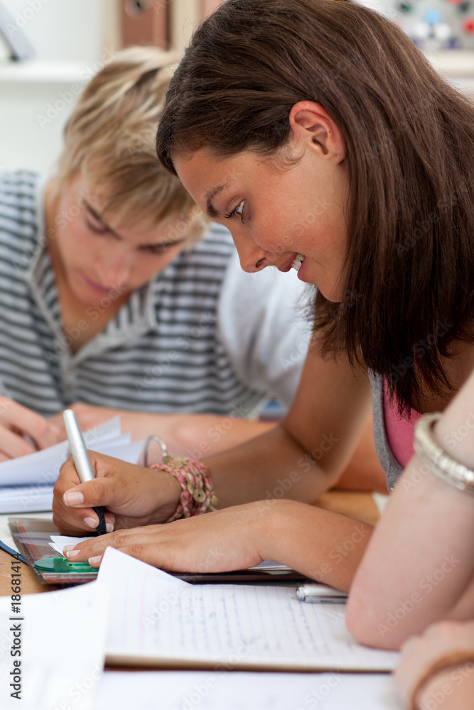 Teen girl studying in the library with her friends Teen girl studying in the library with her friends
