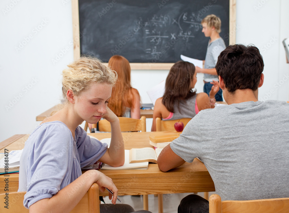 Tired teenager getting bored in a class Tired teenager getting bored in a class