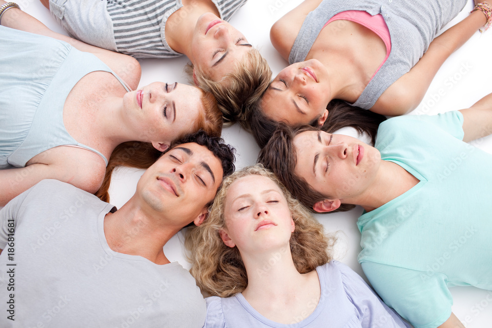 Teens sleeping on floor with heads together
