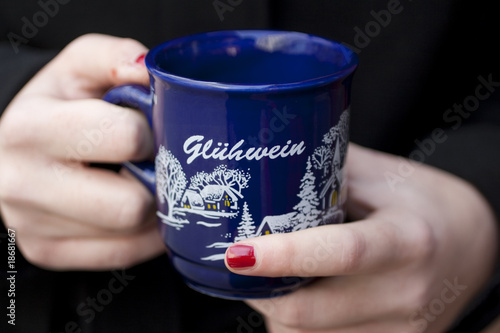 Frauenhände halten Glühweintasse