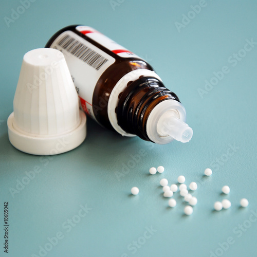 close-up of homeopathic globule pills with bottle