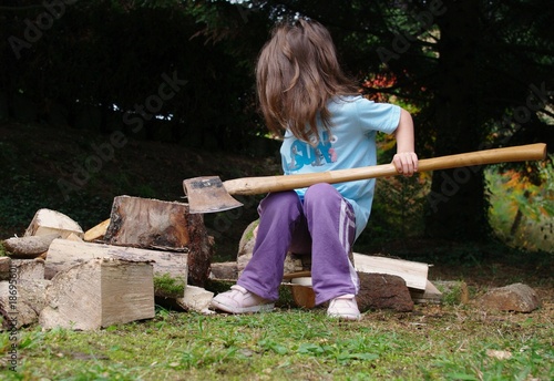 petite fille qui coupe du bois photo