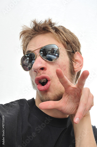 Young man sticking tounge out with aviators