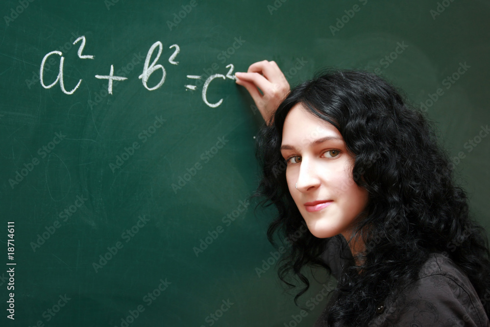 Girl writing formula at the desk Girl writing formula at the desk