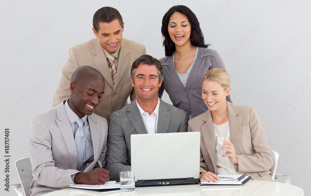 Smiling multi-ethnic business team working in office together Smiling multi-ethnic business team working in office together