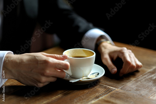 Groom s hands holding cup of coffe