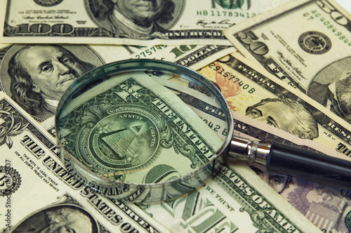 Background from dollar banknotes under a magnifier