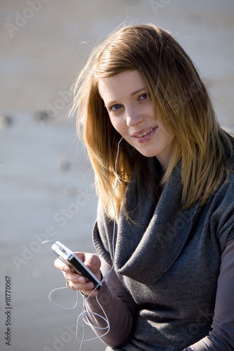 Frau mit MP2 Player am Strand hoert Musik photo