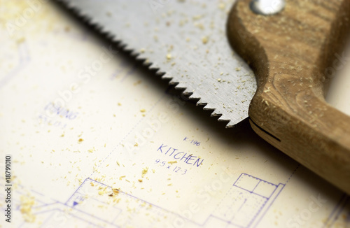 Hand saw lying on blueprints photo