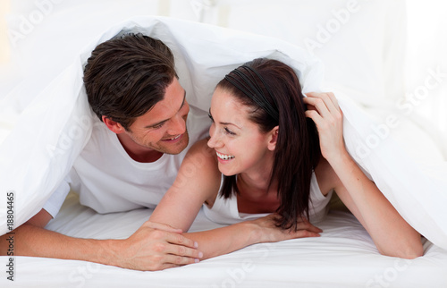 Couple talking together and lying on bed