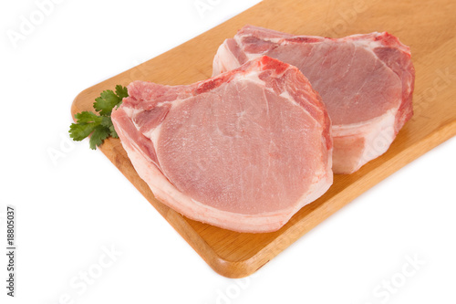 Fresh pork meat on wooden board with parsley