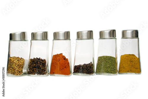 Six jars of spices isolated over white