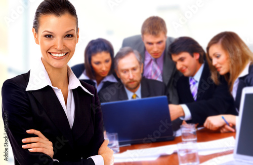 Smiley businesswoman with a group behind him.