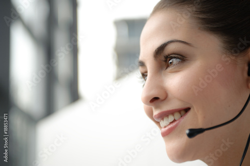 junge frau in büro telefoniert mit headset mit kunden photo