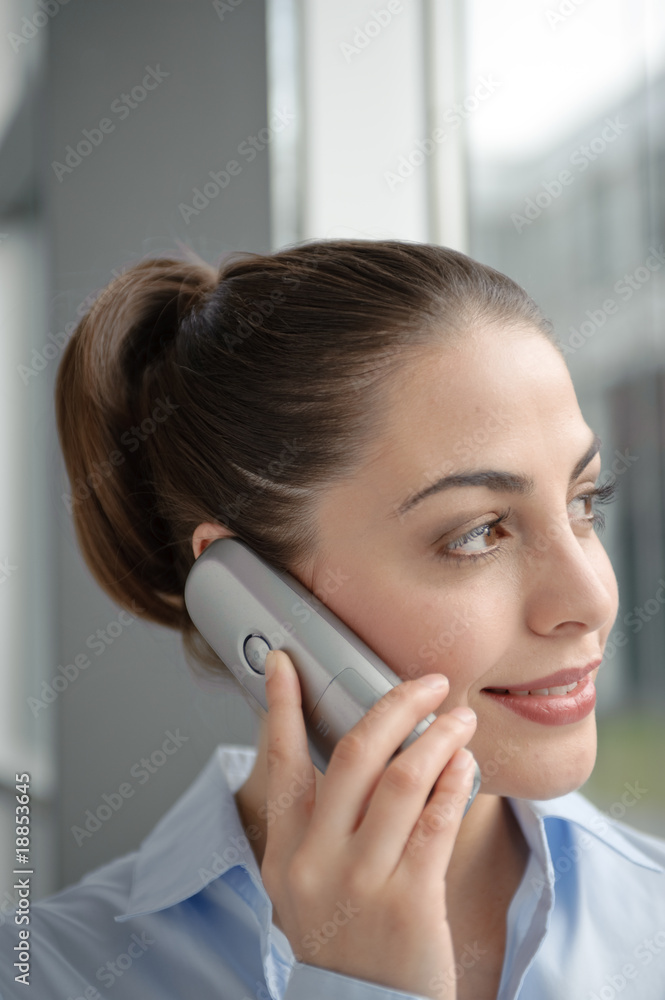 junge geschäftsfrau telefoniert freundlich mit telefon junge geschäftsfrau telefoniert freundlich mit telefon