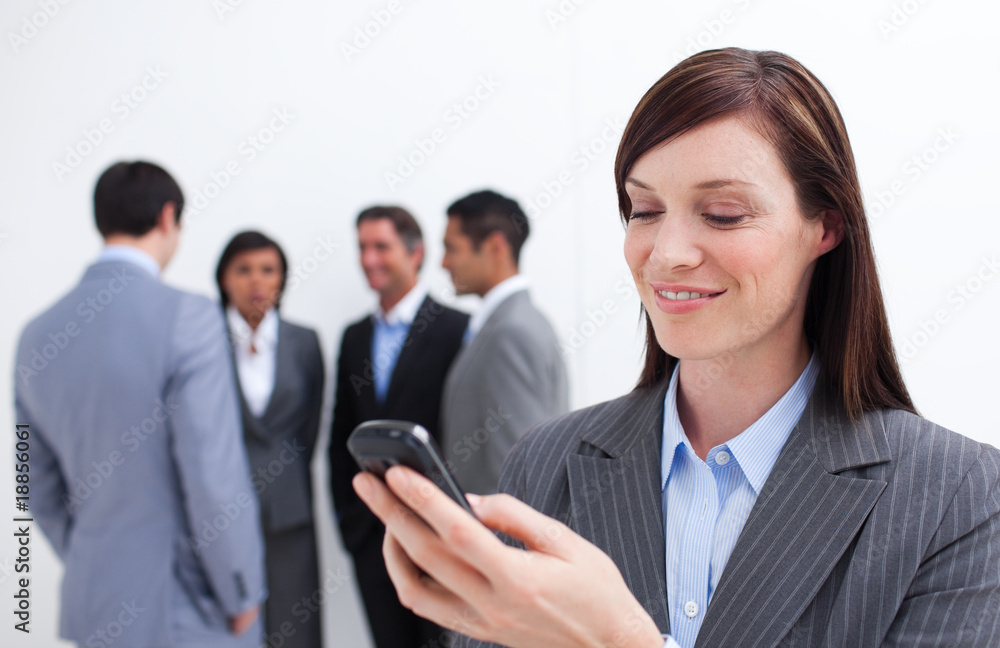 Smiling manager sending a text with a mobile phone Smiling manager sending a text with a mobile phone
