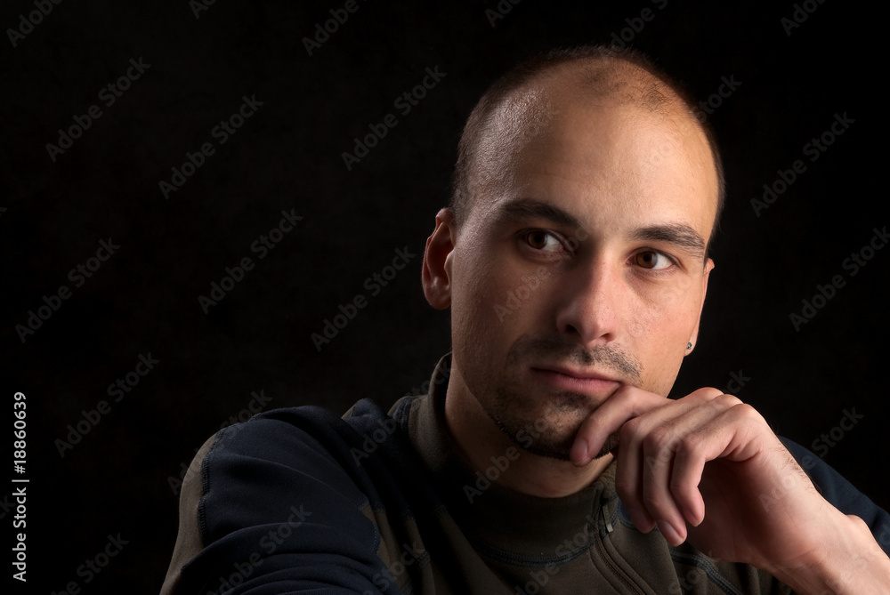 Low-key portrait of pensive young man