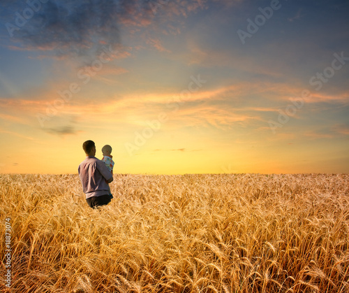 man in wheat field with boy