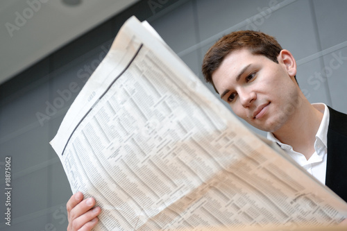 geschäftsmann liest zeitung in bürogebäude