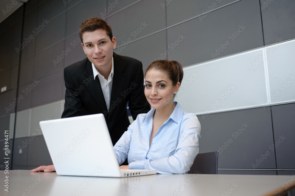 junges business team bespricht sich an tisch mit laptop in büro junges business team bespricht sich an tisch mit laptop in büro