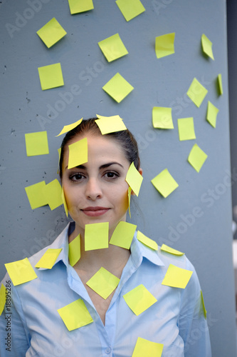 portrait von geschäftsfrau mit post its im gesicht