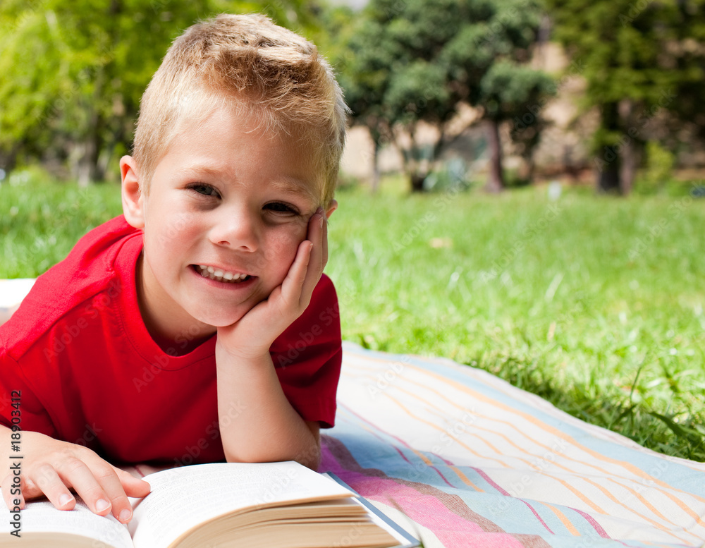 Cute little boy reading at a picnic Cute little boy reading at a picnic