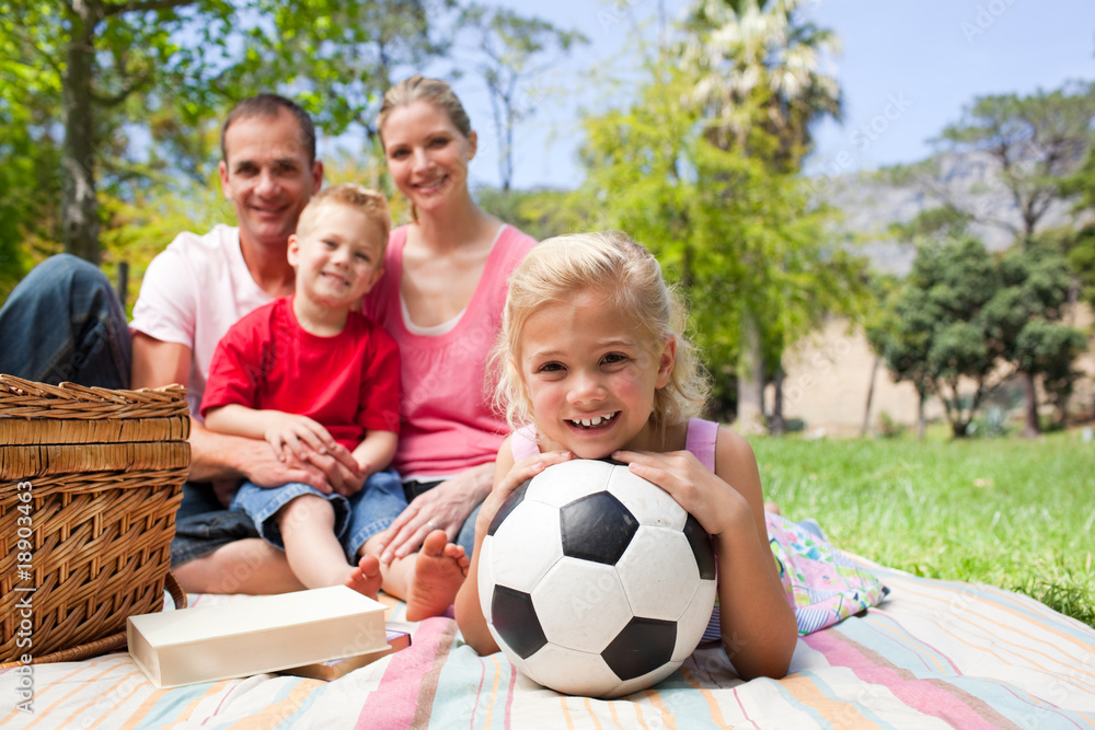 Little blond girl holding a soccer ball at a picnic Little blond girl holding a soccer ball at a picnic