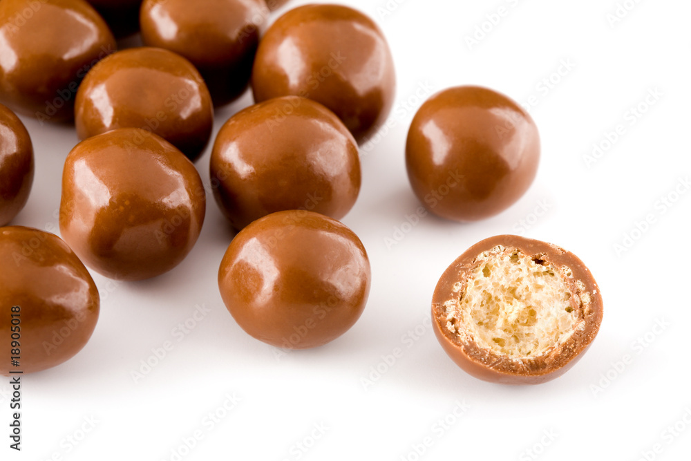 Chocolate balls and a half with crisp filling isolated on white Chocolate balls and a half with crisp filling isolated on white