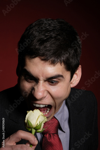Young happy smiling handsome man with rose