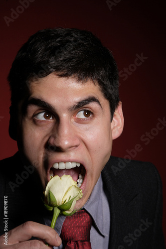 Young happy smiling handsome man with rose