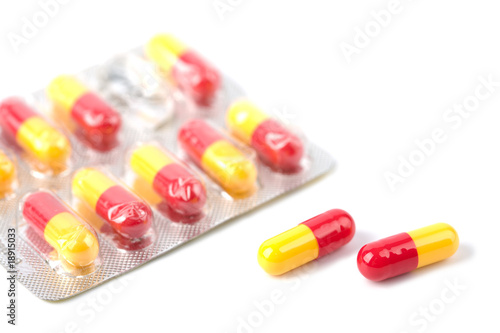 red and yellow capsule pills in blister isolated