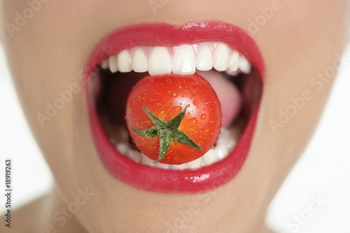 Eating a red tomato macro of woman mouth photo