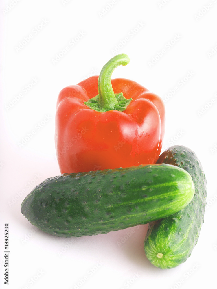 Red Bulgarian pepper and two cucumbers on a white background Red Bulgarian pepper and two cucumbers on a white background