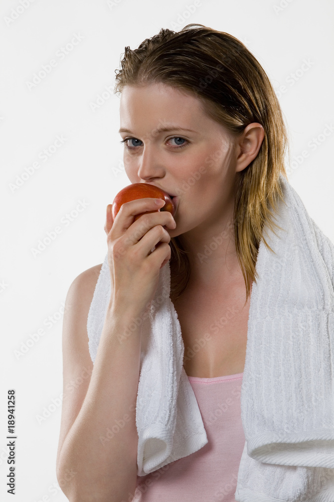 Blonde Frau isst roten Apfel der Sorte Elstar
