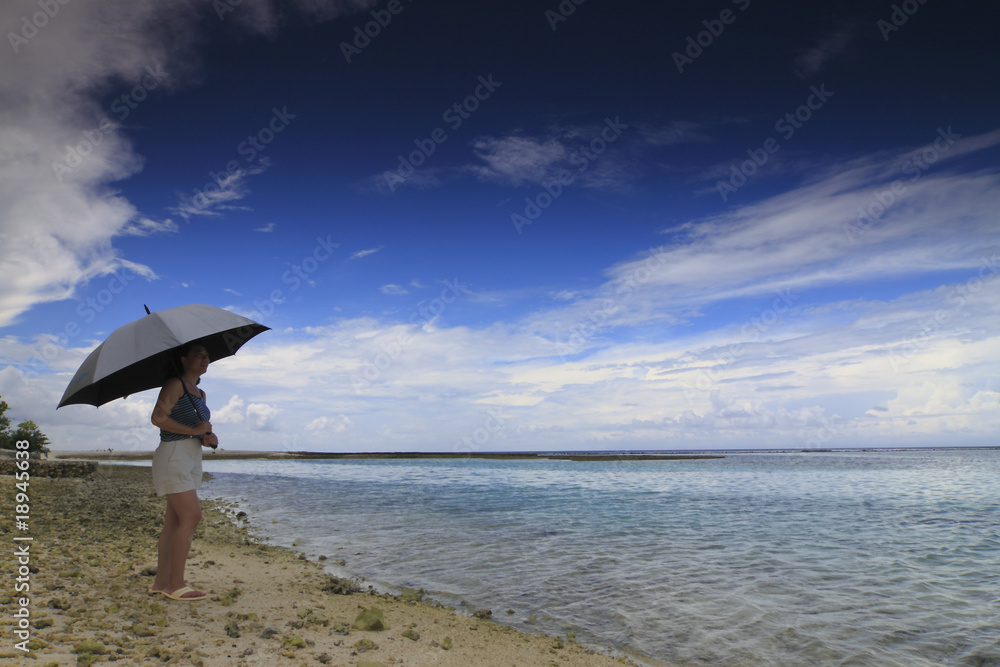 Woman with an umbrella on the beach
