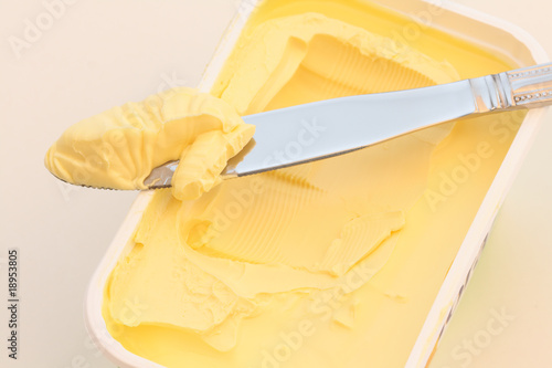 Knife with butter on a butter dish.