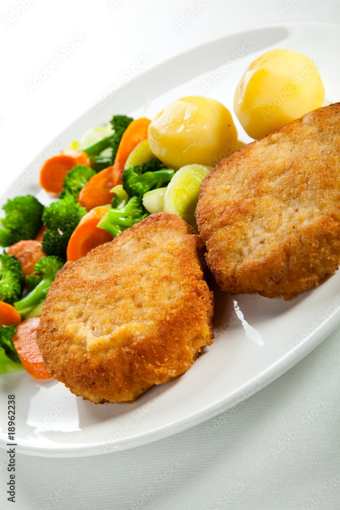 Fried pork chop  with boiled potatoes and vegetables