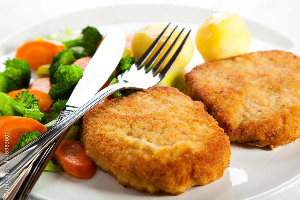 Fried pork chop with boiled potatoes and vegetables Fried pork chop with boiled potatoes and vegetables