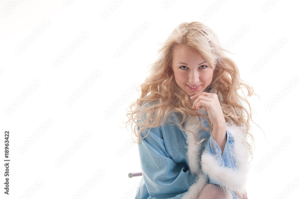 The Snow Maiden in blue fur coat sits and smiles