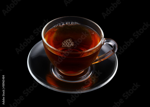 Glass cup of tea isolated on black