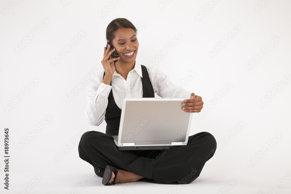 Young Woman Using Laptop and Cell Phone Young Woman Using Laptop and Cell Phone