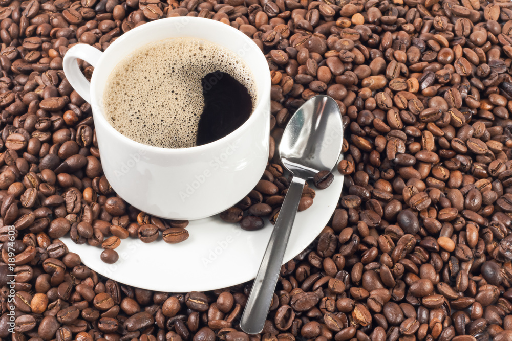 cup of coffee over a lot of coffee beans cup of coffee over a lot of coffee beans