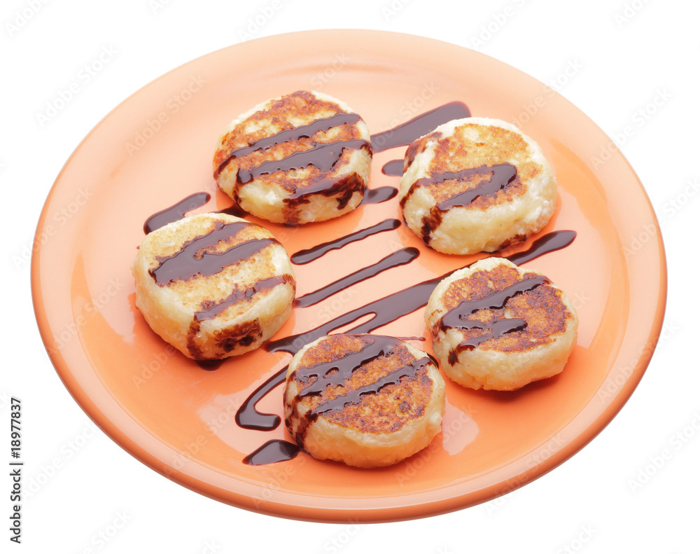 cheese pancakes with chocolate syrup on orange plate