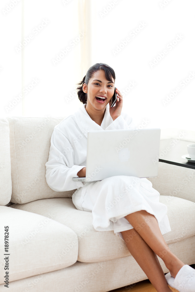 Smiling woman on phone using a laptop Smiling woman on phone using a laptop