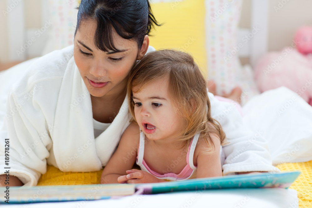 Attentive mother reading with her little girl Attentive mother reading with her little girl