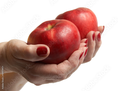 Hand of the elderly lady holding an apple