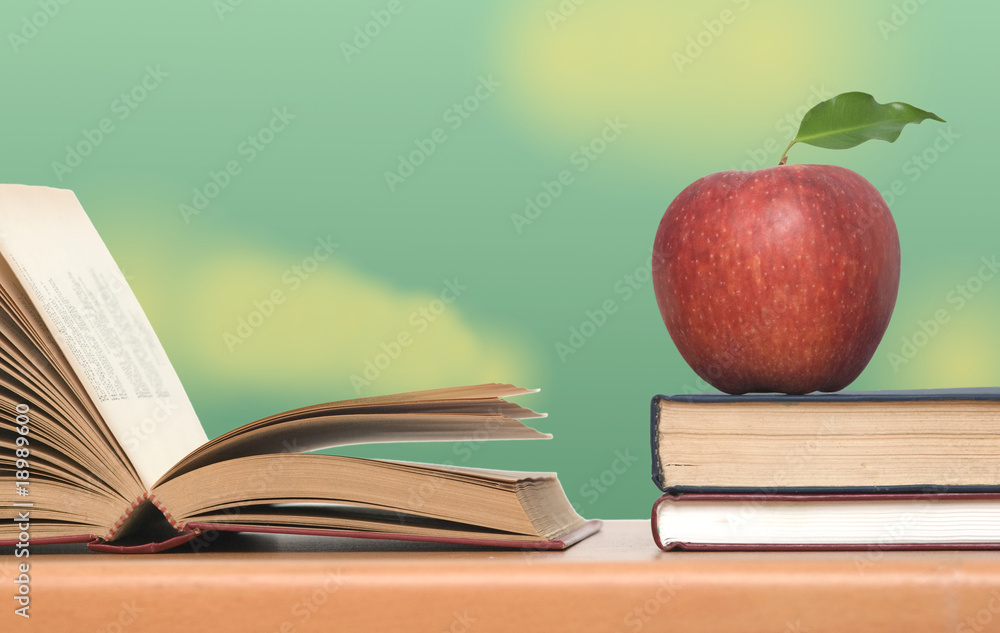 Red apple and books on desk