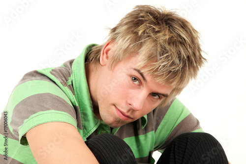 Portrait of teenage boy in striped green shirt, studio shot
